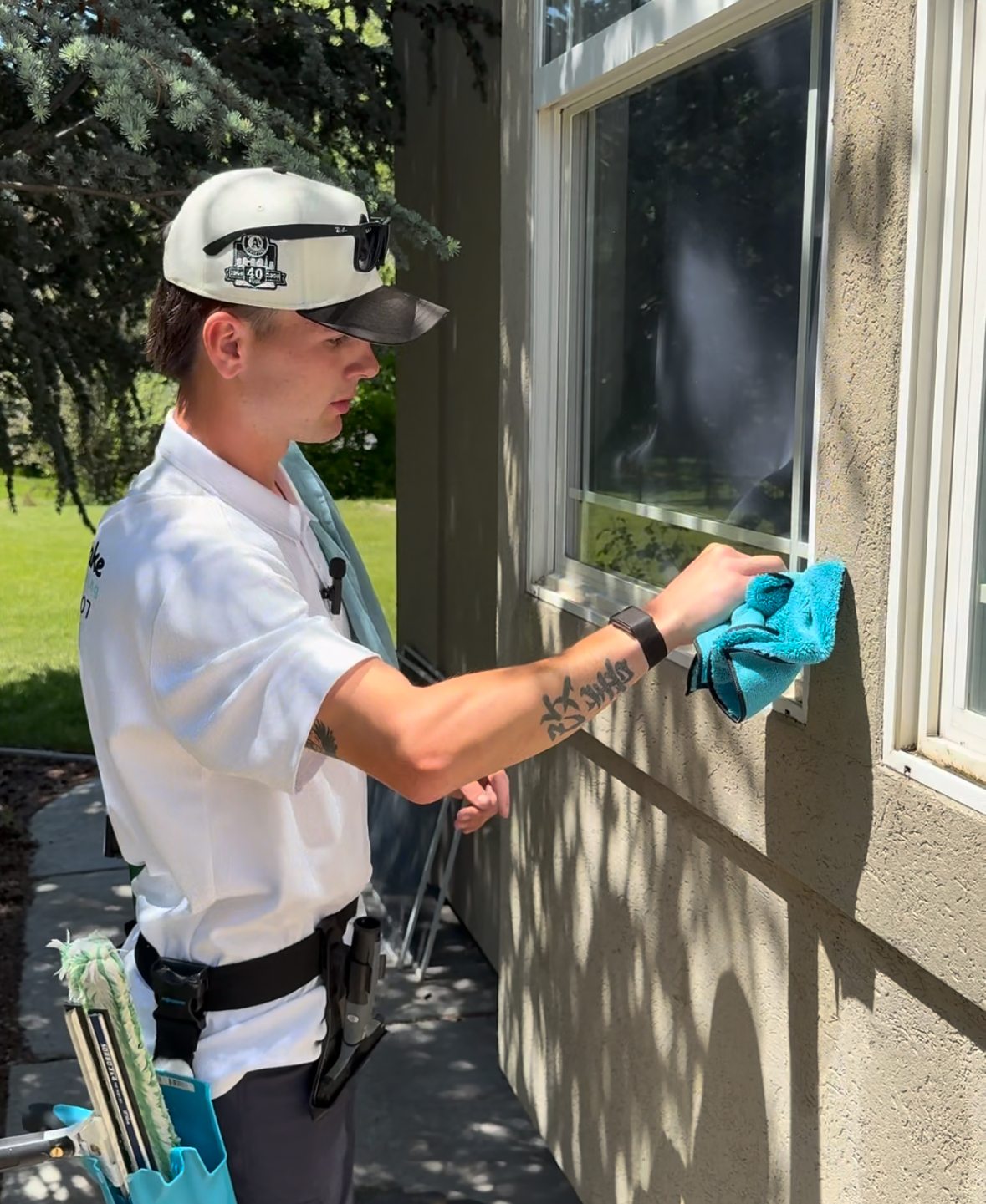 Double Take tech wiping an exterior window frame with a blue microfiber cloth.